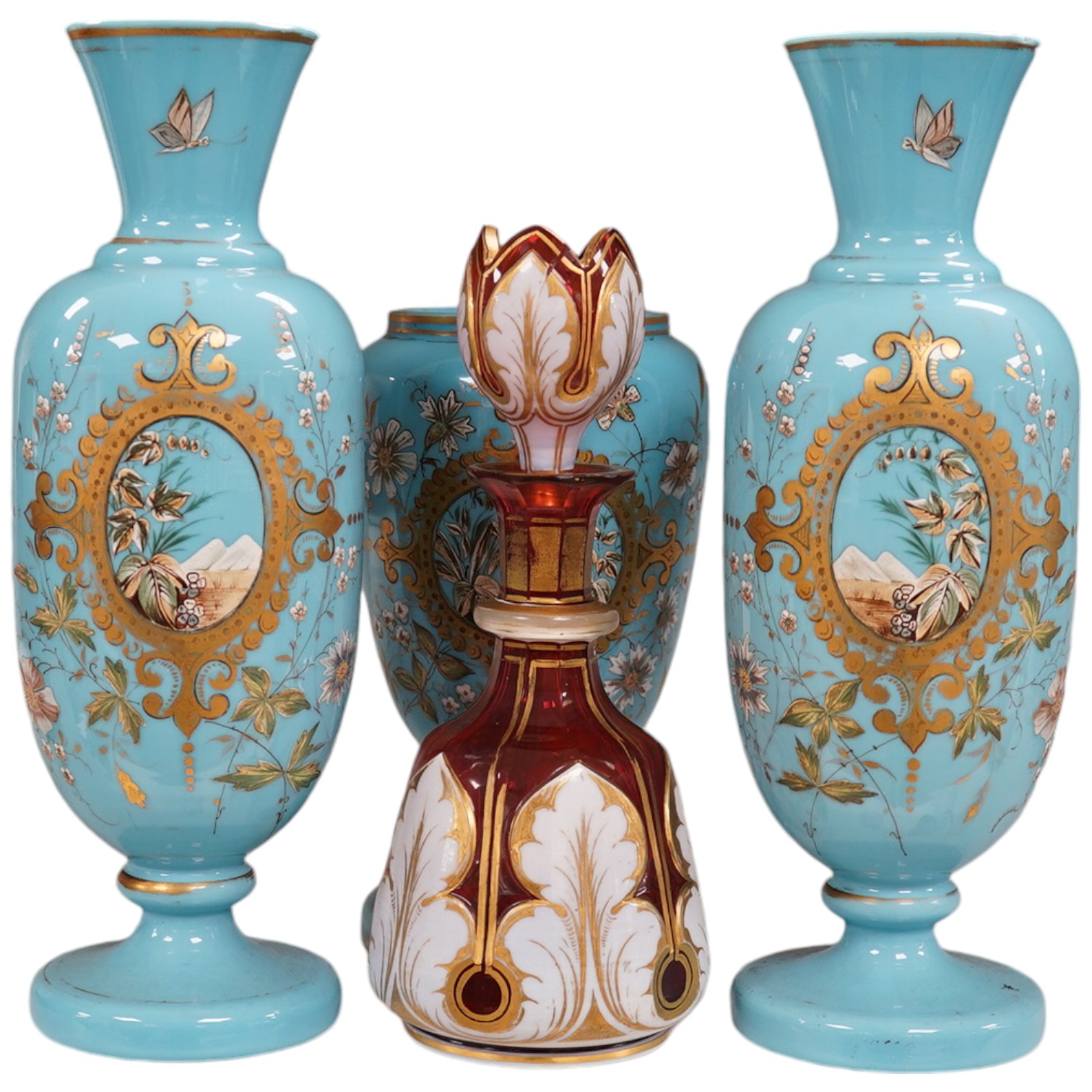 An enamelled glass garniture decorated with Egyptian scenes and a cranberry decanter, largest 29cm high. Condition - poor to fair